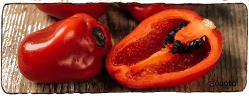 La photo montre un Piment Rocoto coupé en deux, on peut voir ses graines noires