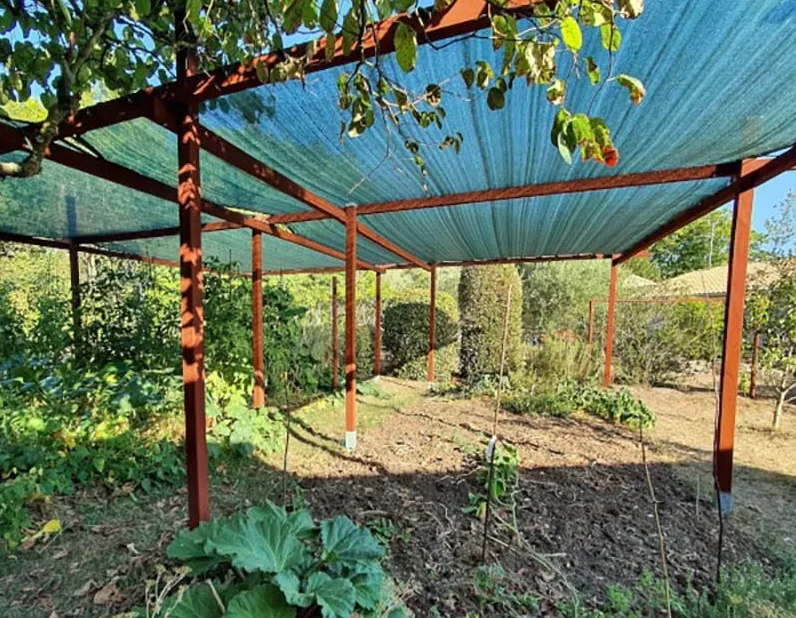 Un voile d'ombrage tendu sur une structure en bois