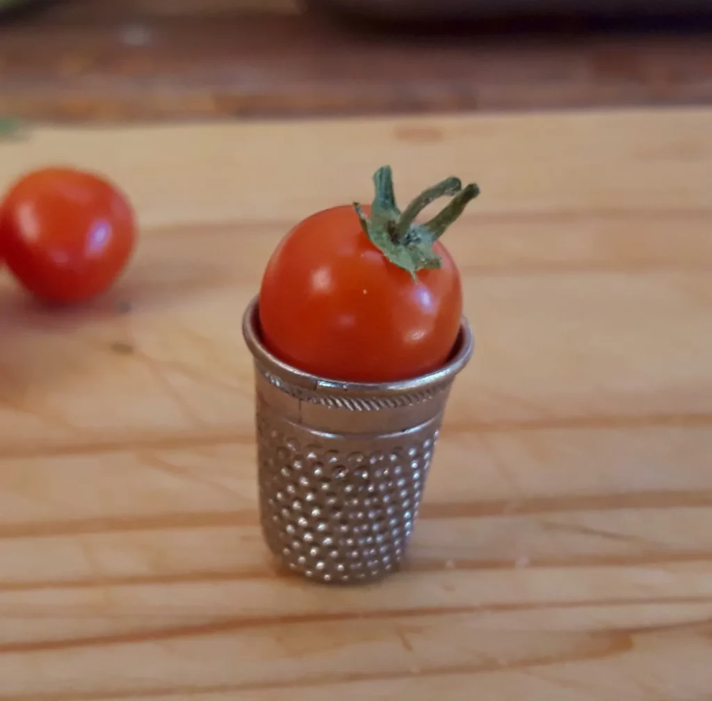 Un dé à coudre avec une tomate rouge dedans!