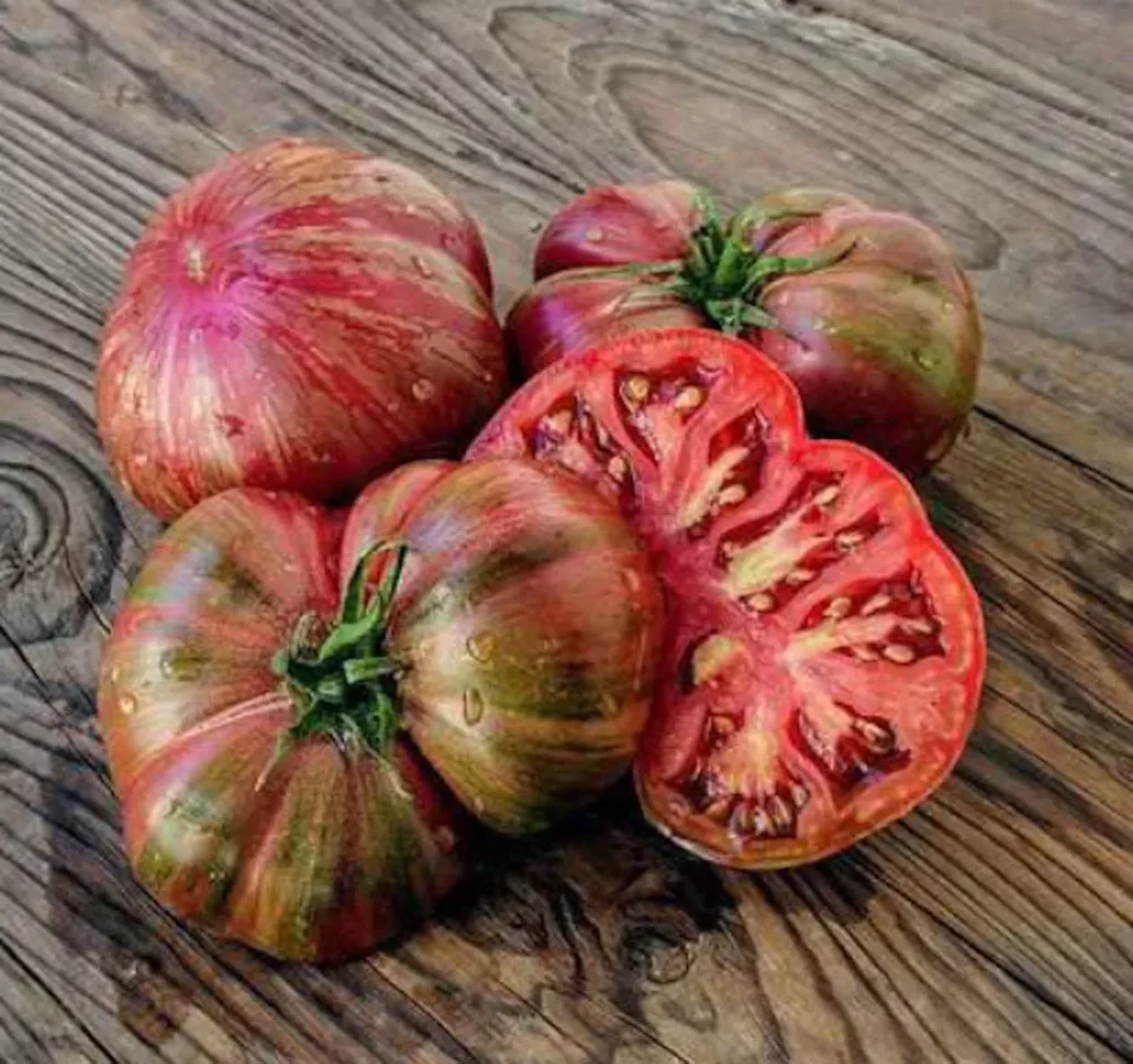 Sur cette image nous voyons trois tomate dont une qui est coupée en deux