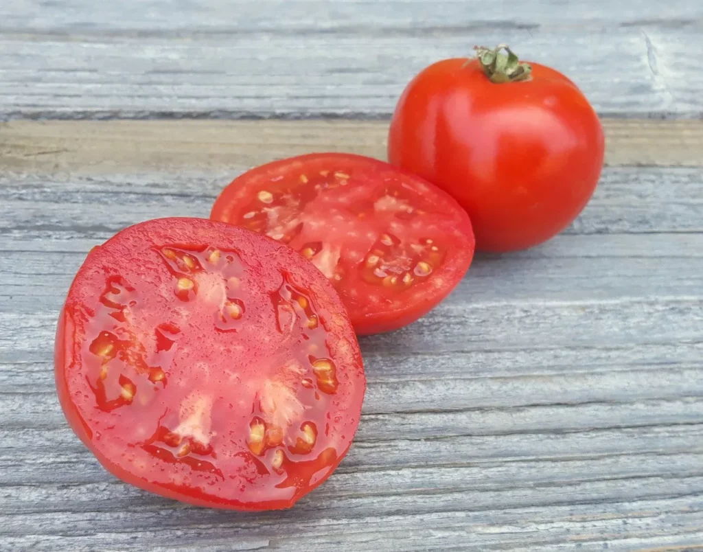L'image montre des tomates coupé sur une planche, elles ont l'air délicieuses