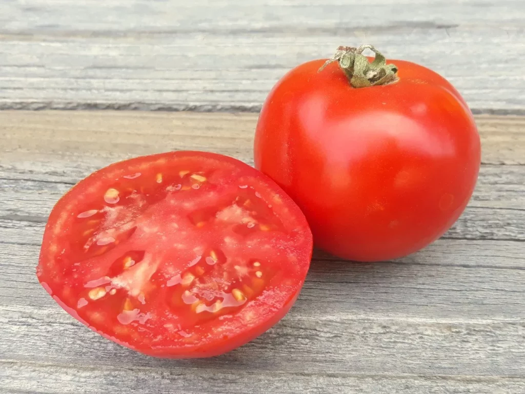 L'image montre deux tomates Thessaloniki, une est entière, l'autre est coupée